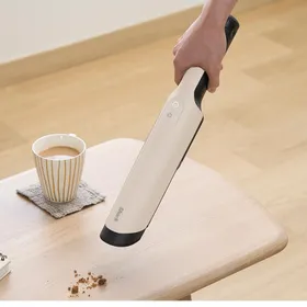 Shark WV321JWH 本体。アイボリーカラーのハンディクリーナーでテーブルの上のごみを吸引している様子